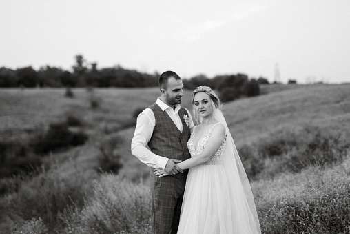 bride blonde girl and groom in a field at sunset light