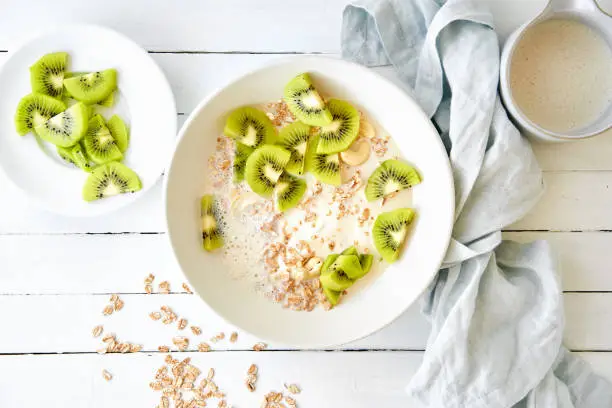 Spelt muesli with sliced kiwi, curd cheese and oat drink