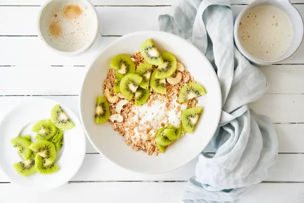 Spelt muesli with sliced kiwi, curd cheese and oat drink