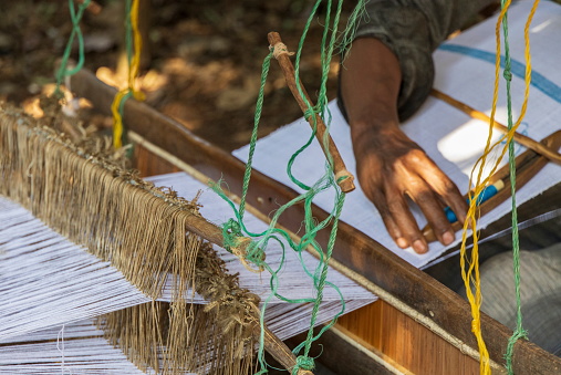 Close up on man's hand weaving, using a  traditional loom, in one of lake Tana's islands. Ethiopian people are known for their weaving skills.