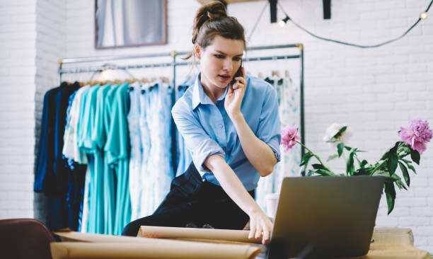 istock Focused seamstress working with gadgets in dress studio 1466426212
