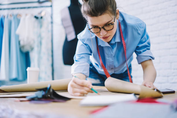 istock Concentrated female dressmaker drawing on paper in studio 1466426326