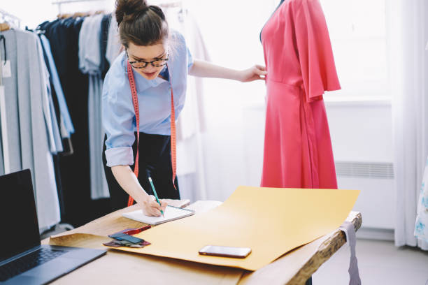 istock Woman dressmaker taking measurements while working 1466426628