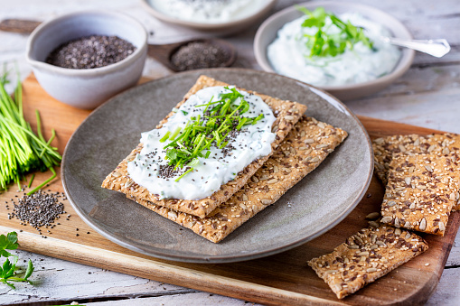 Crispbread, fresh curd, herbs and chia seeds. Fruehlingsquark und Knaeckebrot