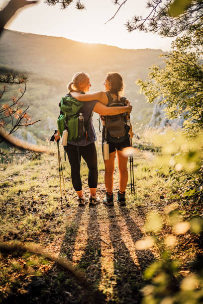 Mother and daughter hikers embracing each other stock photo