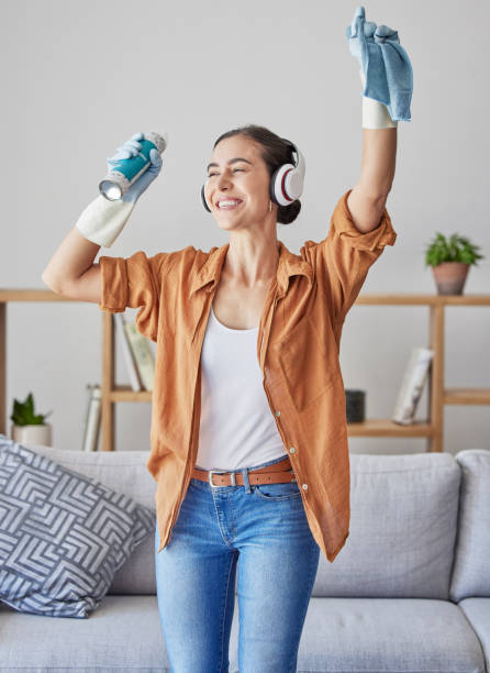 happy, dance or woman cleaning with music streaming on headphones to relax to radio audio at home. smile, wellness, or excited cleaner dancing with cloth or spray bottle to wipe dirty dusty bacteria - spring cleaning women cleaning dancing imagens e fotografias de stock