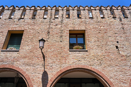 Brick wall of a medieval building with windows in the city of Padua, Italia
