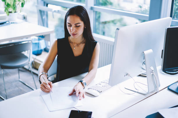 istock Pensive businesswoman writing notes on paper in office 1466431834