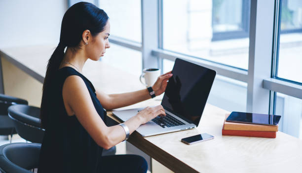 istock Focused female freelancer browsing laptop in workspace 1466431865