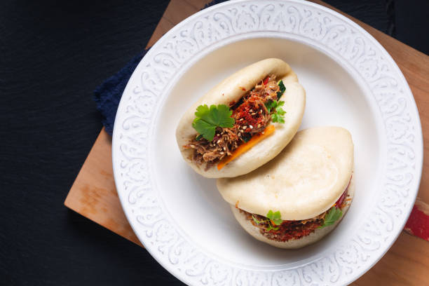 istock Food concept Homemade organic Pulled Beef Bao Buns or Gua Bao in white ceramic plate on black background with copy space 1466433303