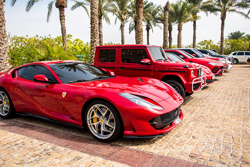 Dubai, United Arab Emirates  February 10, 2021: A red Ferrari car next to other luxurious stylish modern cars parked near the hotel in Dubai.