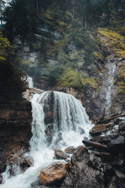 istock Beautiful waterfall (Kuhfluchtwasserfälle/Kuhfluch waterfall) in Bavaria, Germany on an overcast day with light rain, surrounded by autumnal and green nature and steep rock faces. 1466444244