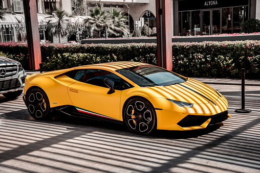 Dubai, United Arab Emirates  February 5, 2021: luxury yellow car Lamborghini on a street near hotel on the famous district Jumeirah Beach in Dubai.