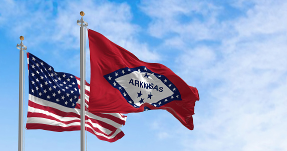 Arkansas state flag waving with the national flag of the United States of America on a clear day. Rippled textile. 3d illustration render