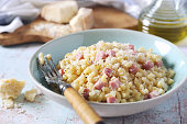 Italian Cuisine. Stortini pasta risotto  with fresh ham cubes, grated parmesan cheese and olive oil