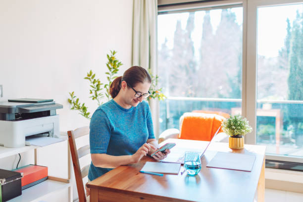 istock Adult woman working from home using laptop and mobile 1466452029