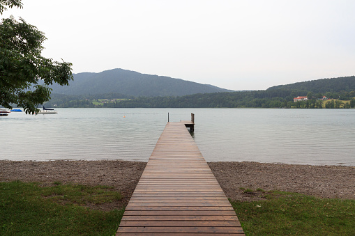 Panorama view of lake Tegernsee, jetty, sailboats and mountains in Gmund, Germany