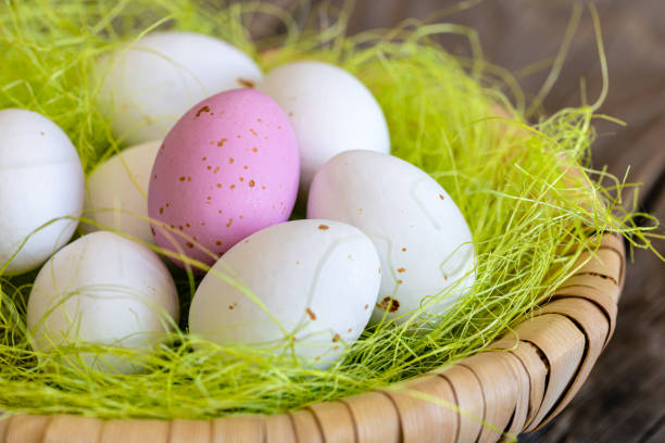 istock Easter composition with colorful chocolate eggs in a nest on wooden background. 1466453852