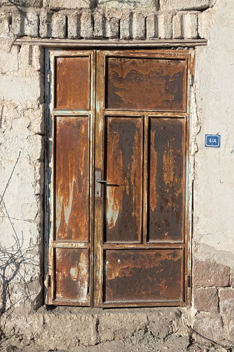 Old metal rusty gray warehouse door
