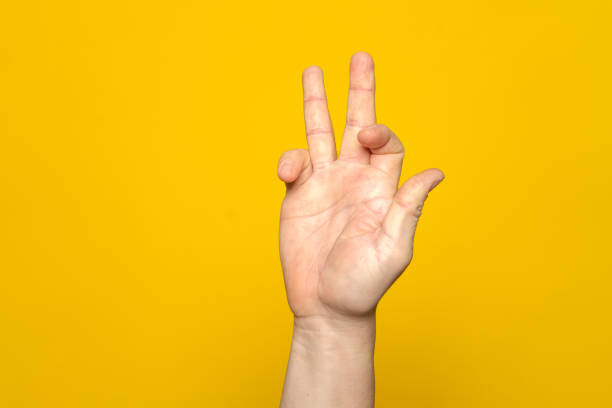 istock Tough man's hand making a strange and complicated gesture with his hand. It can represent a surfer, gippie or meditation gesture isolated on yellow background. 1466455875