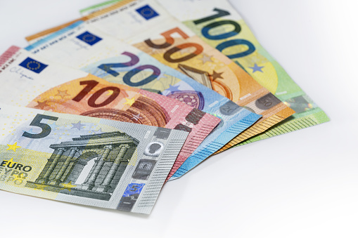 Some banknotes in euro currency on a light gray background, finance concept, copy space, selected focus, narrow depth of field