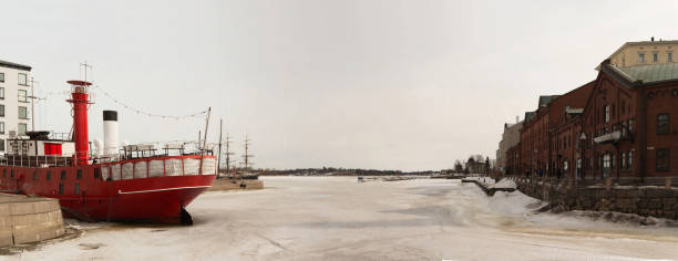 View of Helsinki harbour in winter. Iced water, red ship. Finland