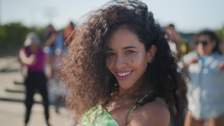 Portrait of mid adult woman dancing reggaeton during street party with her friends outdoors