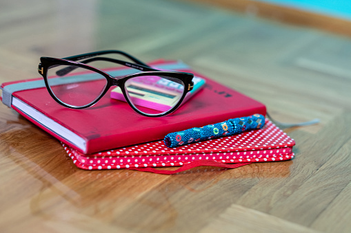 portrait of a notebook and glasses on a table