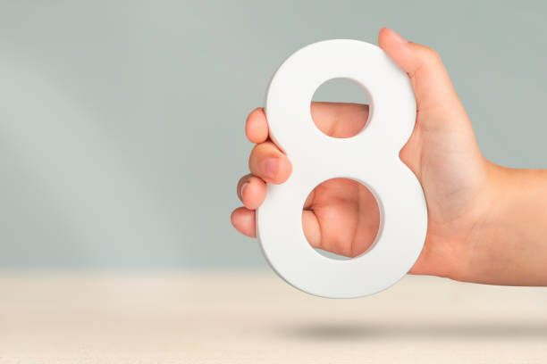 istock Eight in hand. A hand holds a white number 8 on a blurred background. Concept with number eight. Birthday 8 years, percentage, eighth grade or day, international women's day. 1466465106