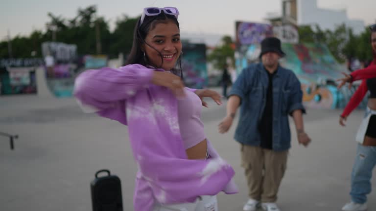 Young woman dancing hip hop at skateboard park