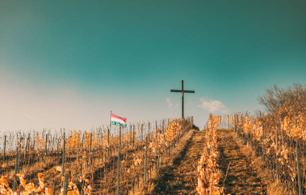 un paysage d’automne avec une croix chrétienne au sommet d’une colline. une colline au coucher du soleil. une croix de jésus sur une colline au luxembourg - god landscape majestic cross photos et images de collection