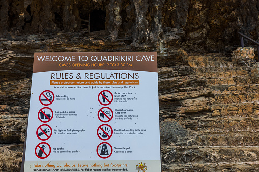 Aruba. Oranjestad. 02.15.2023. Close-up view of rules and regulation information desk for visitors infront of Quadirikiri Caves.