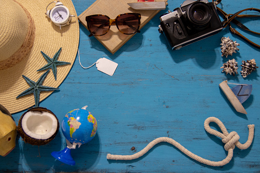 Vacation concept. Seashells and old vintage camera on blue background, copy space