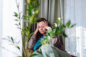 Adult woman with depression sitting at chair at home