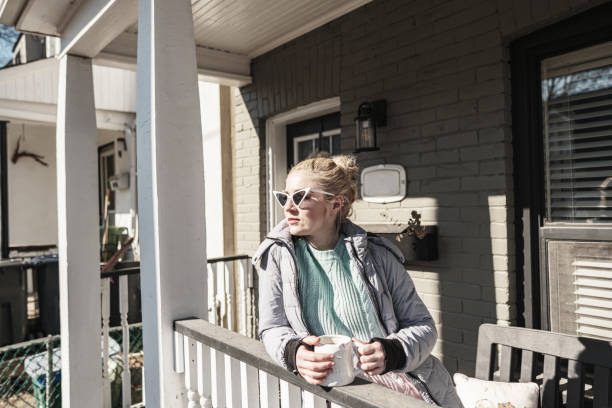 istock Millennial woman enjoying sunny day in front of the home 1466478607