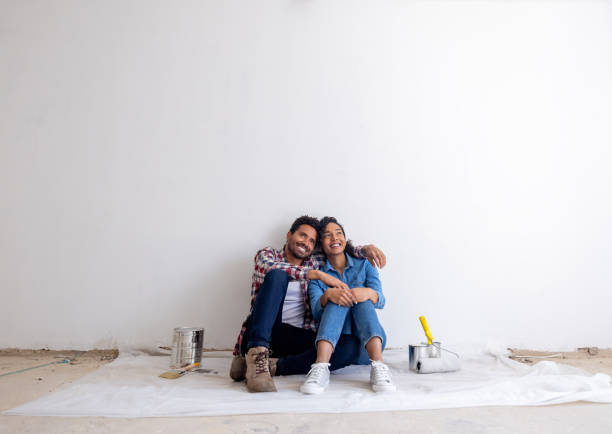 Loving couple taking a break from painting while remodeling their house