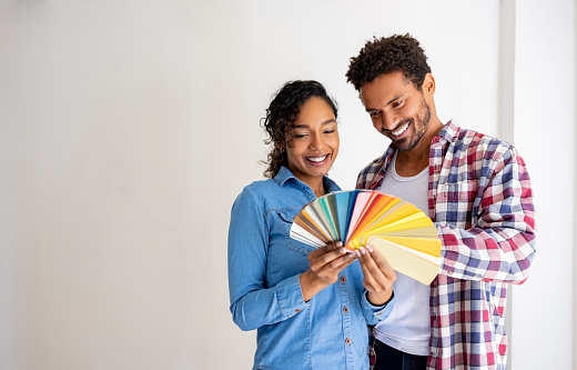 Couple choosing a color for the walls while remodeling their house