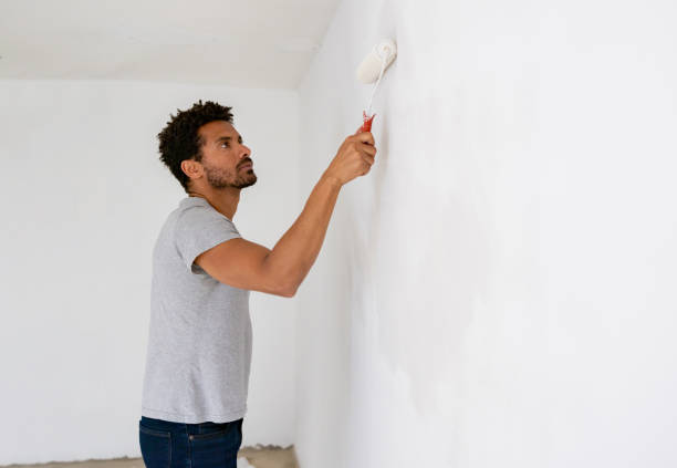 istock Man painting a wall while remodeling his house 1466479974