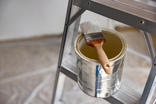 Close-up on a paint can on a ladder with a paint brush - home improvement concepts