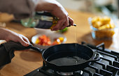 Close Up Photo Of Manâs Hands Pouring Olive Oil In Frying Pan