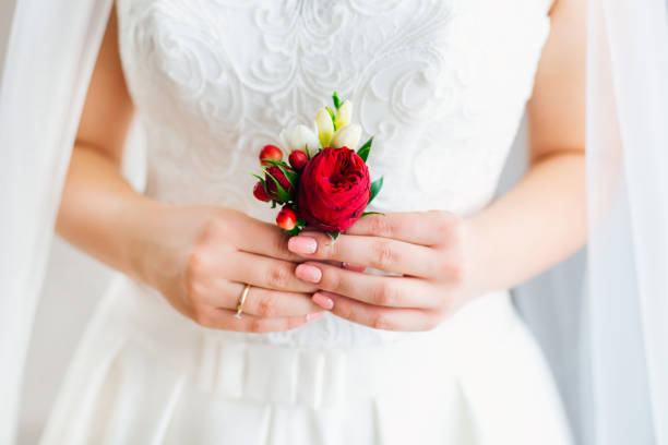 gros plan des mains de la mariée tient une boutonnière. boutonnière w - wedding dress wedding domestic room bride photos et images de collection