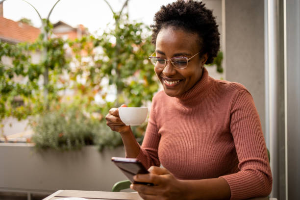 istock Smiling woman using mobile phone at the bar 1466485771