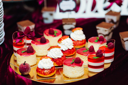 chic desserts on the tray are decorated with raspberries. wedding