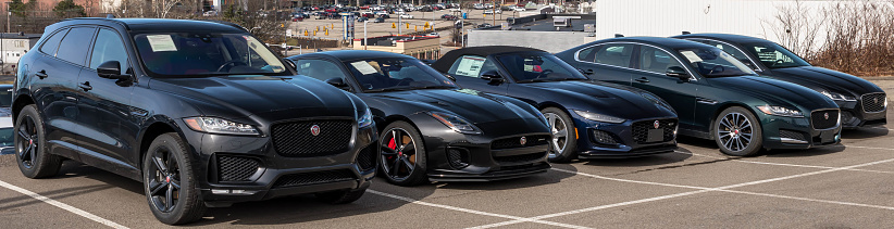 Monroeville, Pennsylvania, USA February 12, 2023 Five different, black Jaguar vehicles for sale at a dealership on a sunny winter day