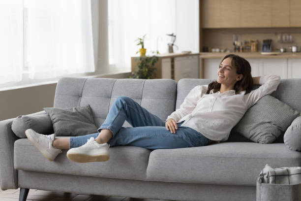 istock Positive peaceful young woman resting on sofa at home 1466487830