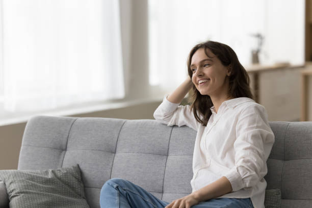 istock Happy pretty young woman relaxing on comfortable couch 1466487833