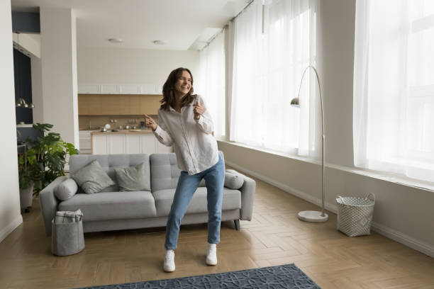 istock Cheerful active young woman dancing at cozy home 1466487916