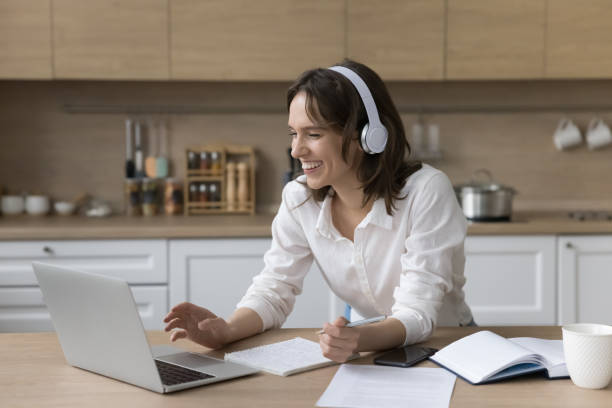 istock Joyful pretty student girl in wireless headphones watching learning webinar 1466488930