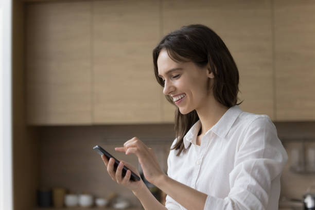 istock Happy pretty young cellphone user woman using online application 1466488946