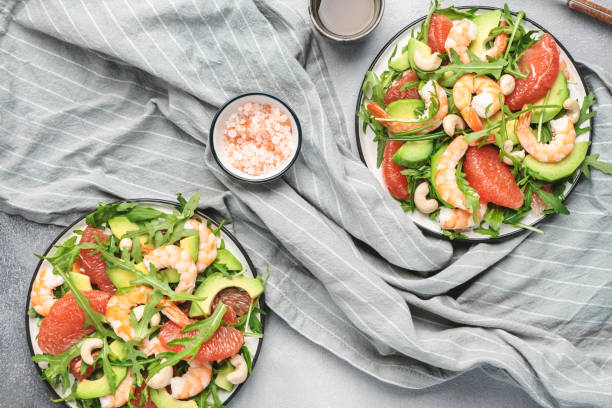 istock Fresh salad with shrimps, avocado, grapefruit, arugula and cashews. Gray kitchen  table background, top view 1466489391